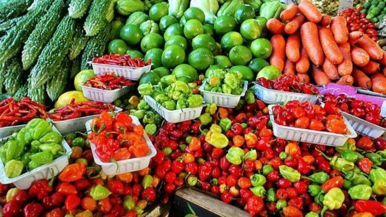 Colourful market stall with chillies, limes and carrots