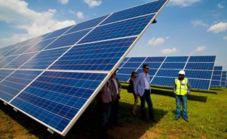 Engineers inspecting solar panels at solar farm
