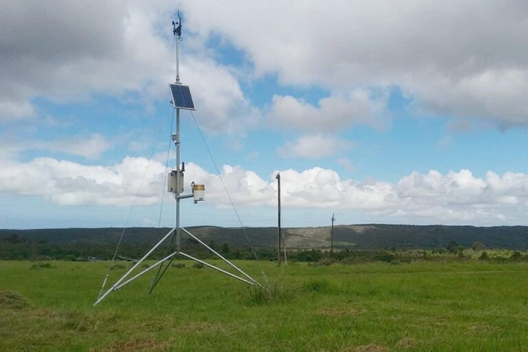 Solar-powered weather station in grassy countryside field