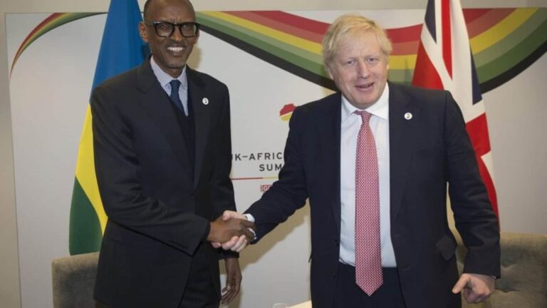 Two leaders shaking hands before UK and Rwanda flags