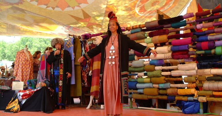 Woman modelling traditional dress at colourful fabric stall