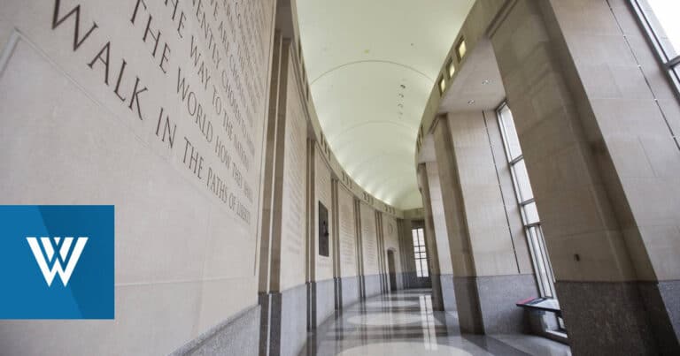 Marble memorial corridor with inscriptions and tall windows