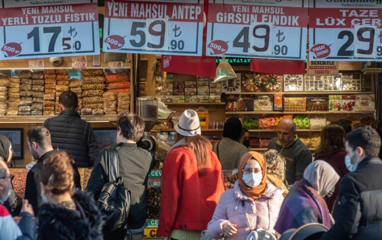 Crowded market stall selling nuts with price signs
