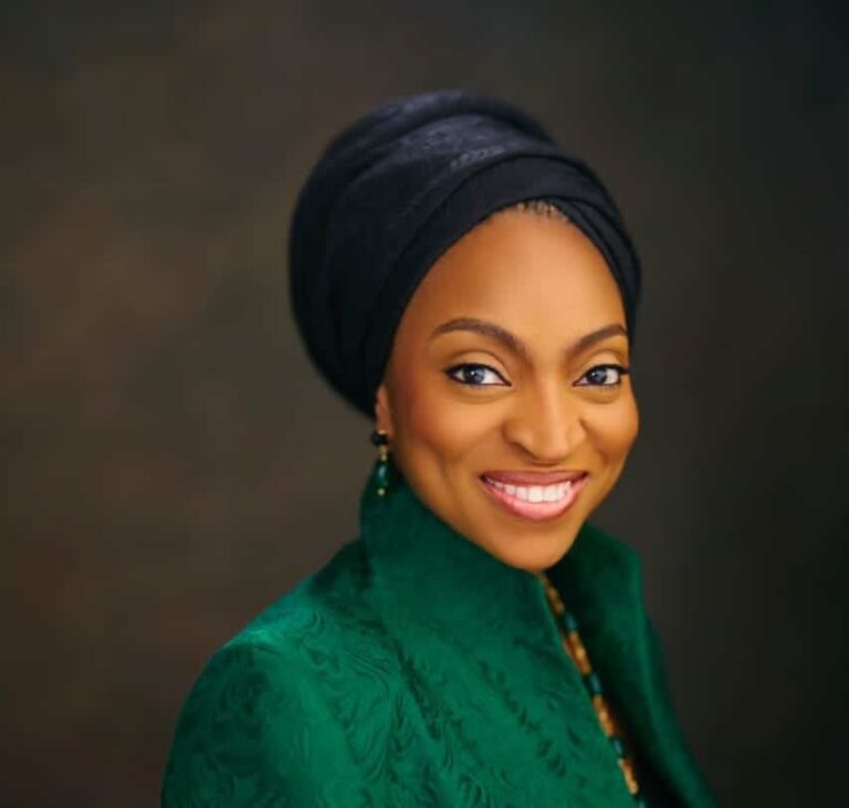 Smiling woman in green outfit and headwrap portrait