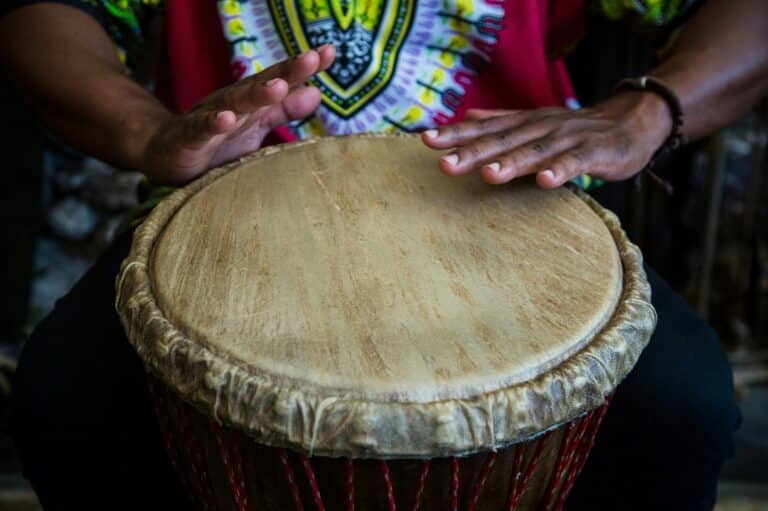 Hands playing a traditional djembe drum