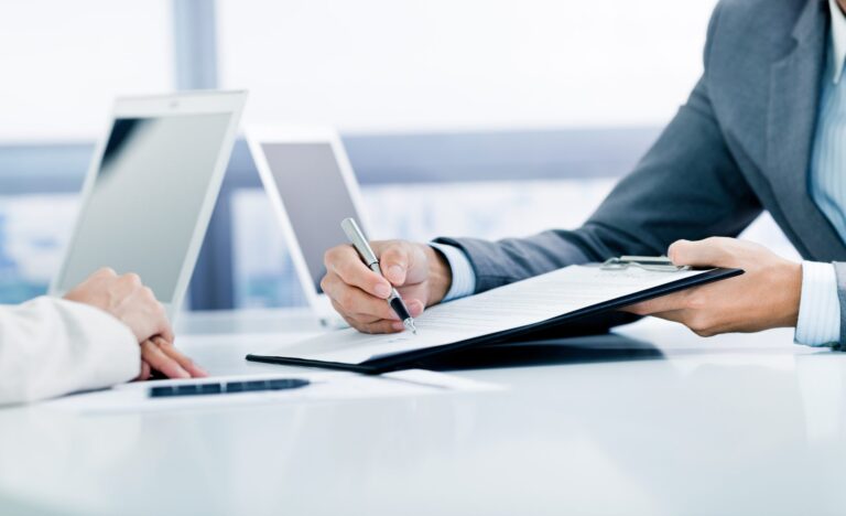 Professional signing document during office meeting