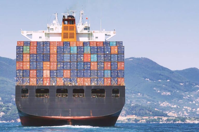 Container ship loaded with colourful freight containers at sea