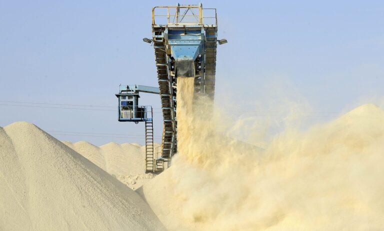 Conveyor belt pouring sand onto quarry stockpile