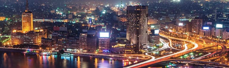 Night city skyline with illuminated river and highways