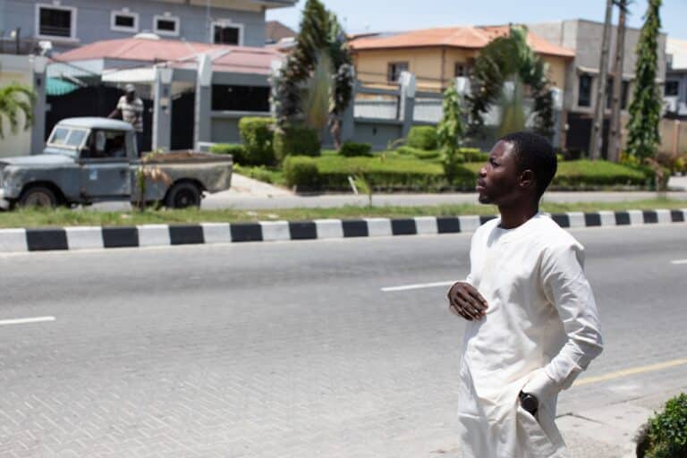Man standing by roadside in residential neighbourhood